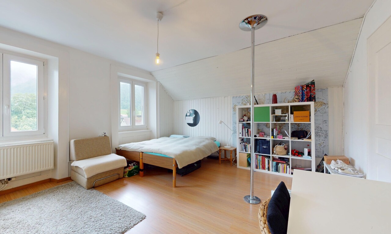 room with wood finished floors, lofted ceiling, and radiator