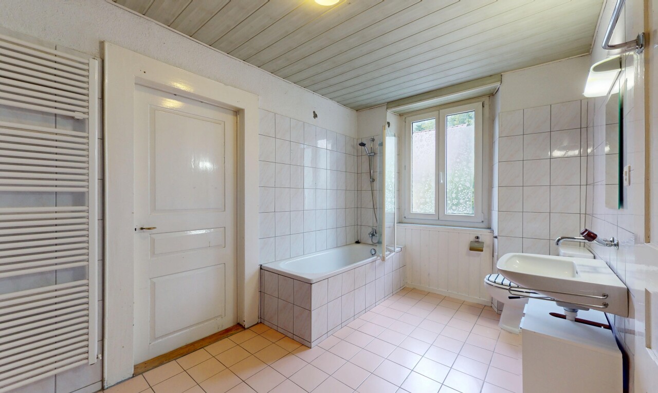 full bathroom featuring radiator heating unit, tile patterned floors, tiled shower / bath combo, tile walls, and a towel warming rack