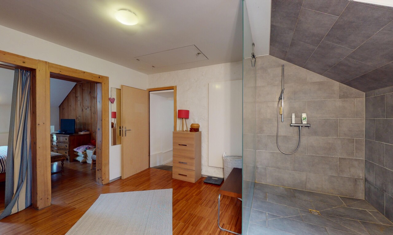 full bathroom featuring lofted ceiling, walk in shower, and wood finished floors