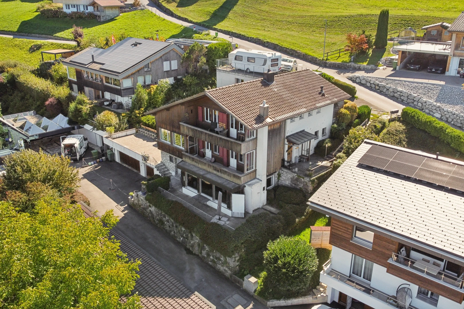 view of property with a balcony, a garage, and driveway