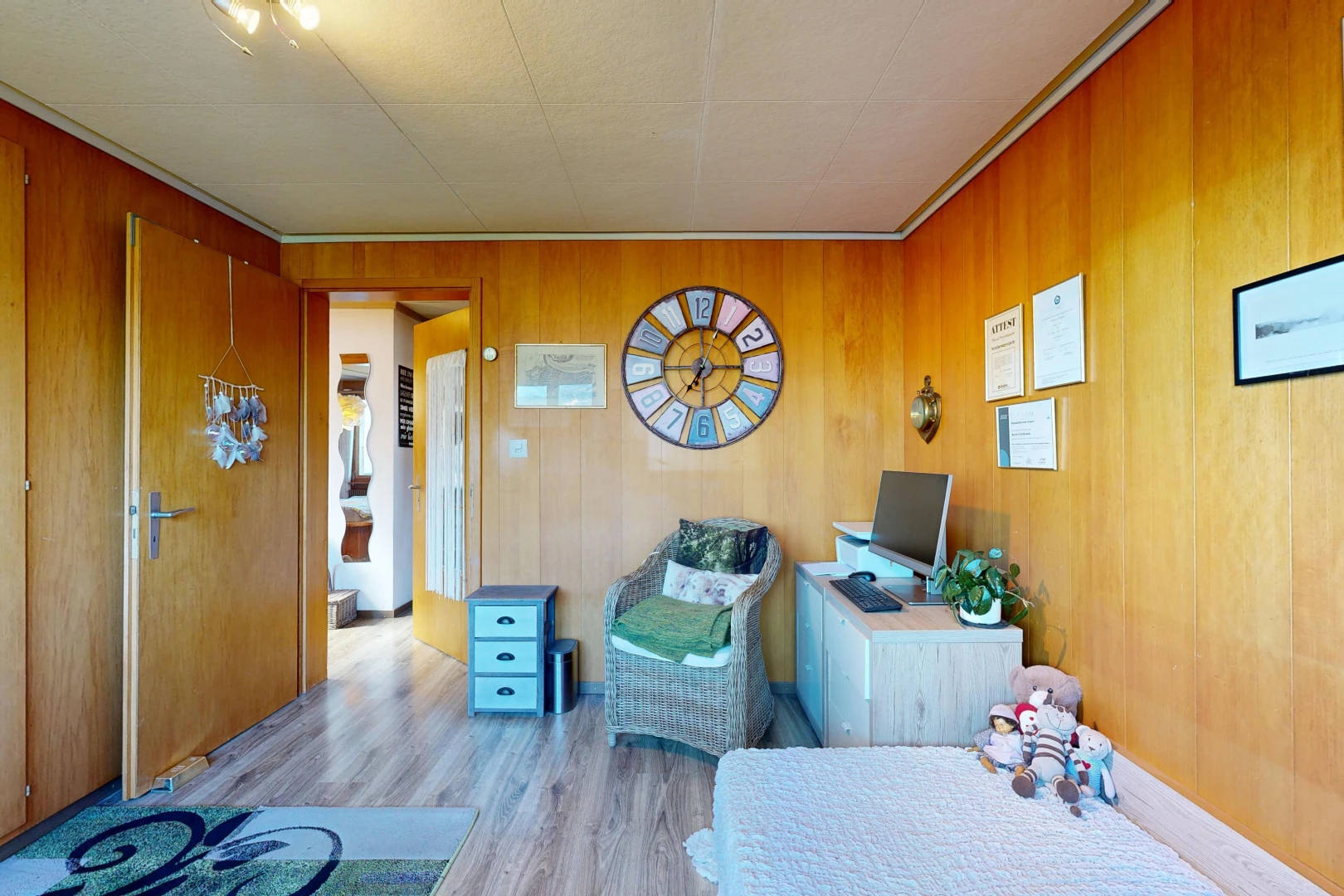 room with light wood-style flooring and wooden walls