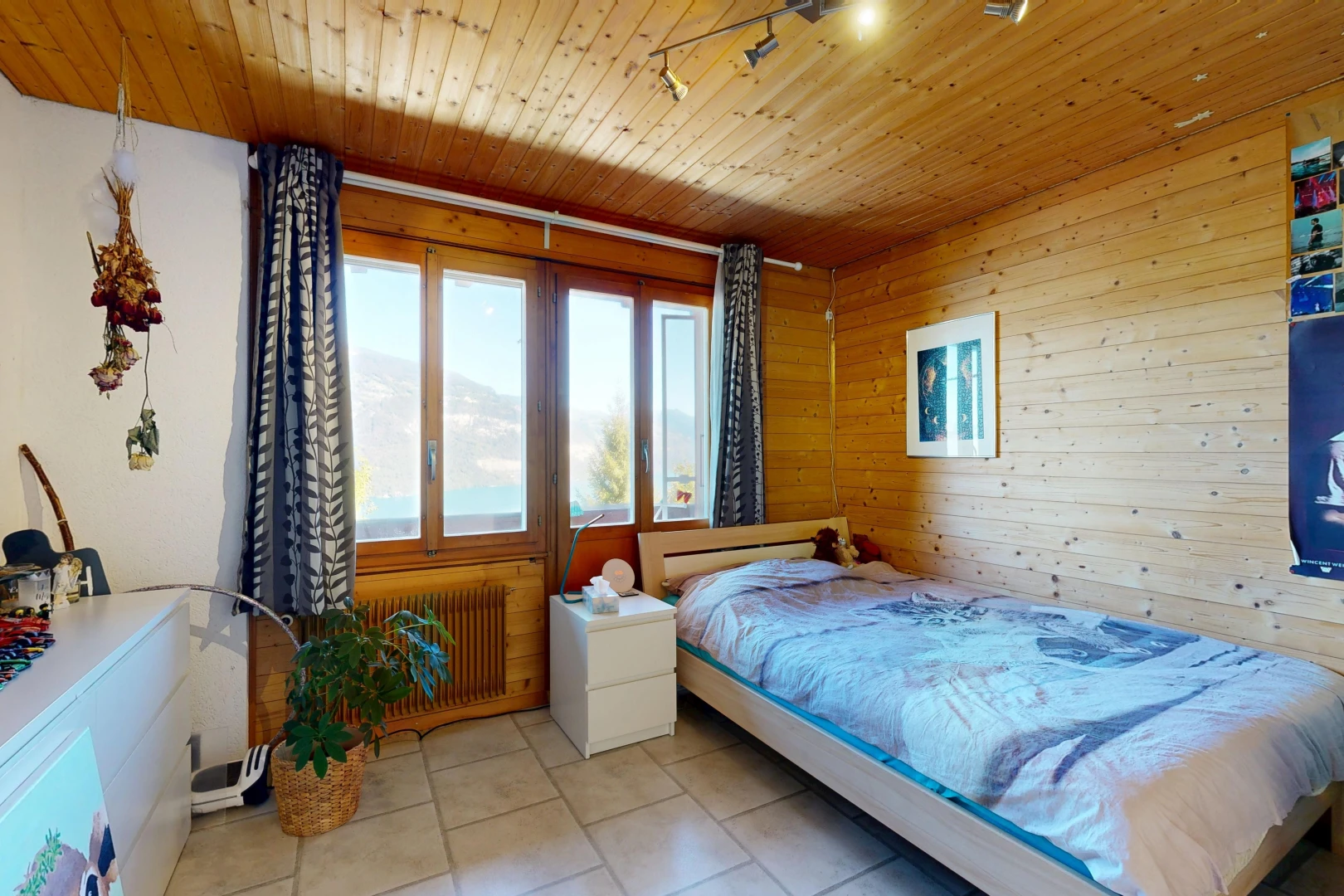 room / bedroom featuring wooden ceiling, wood walls, radiator, track lighting, and light tile patterned floors