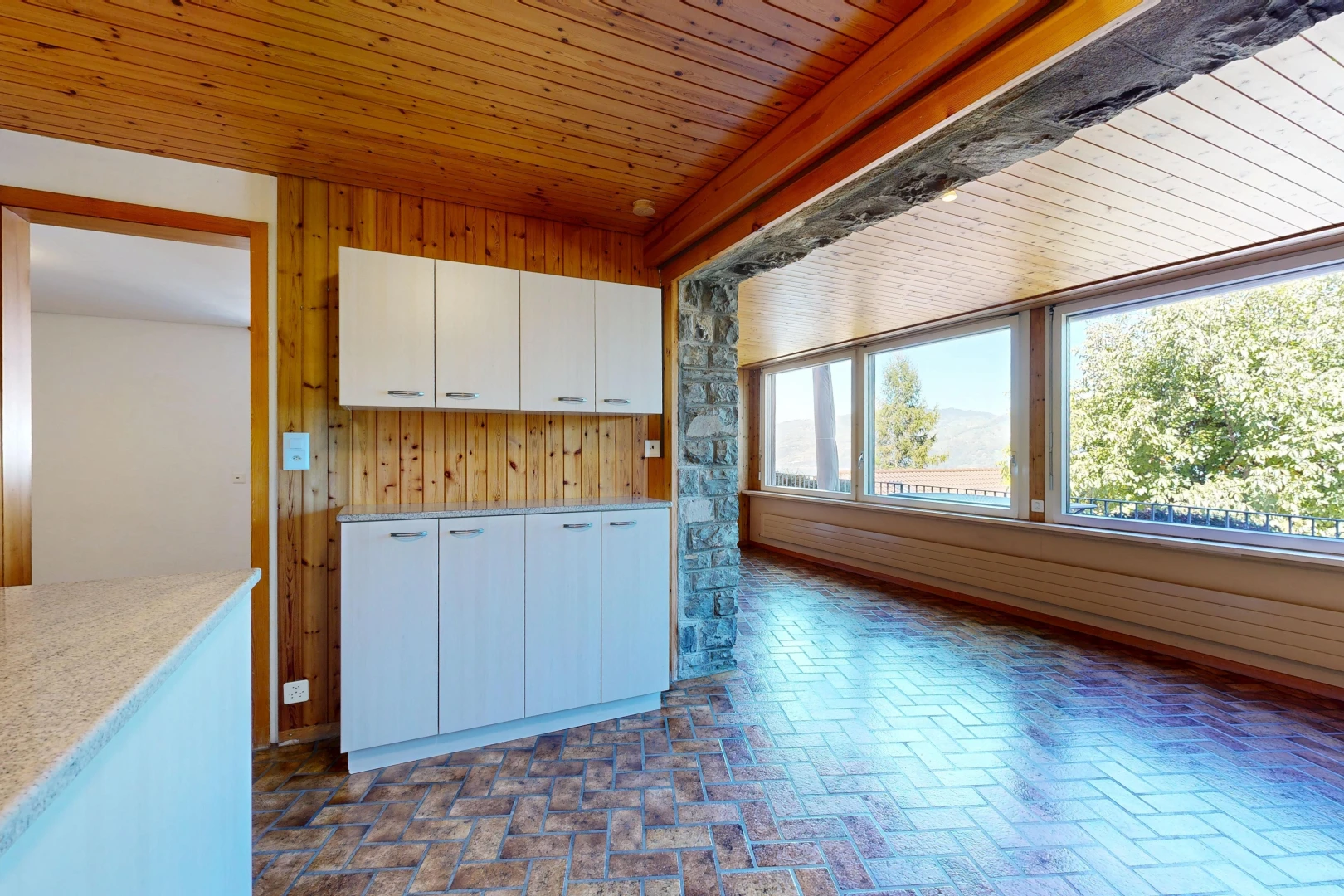 kitchen with wood ceiling, wooden walls, and brick flooring