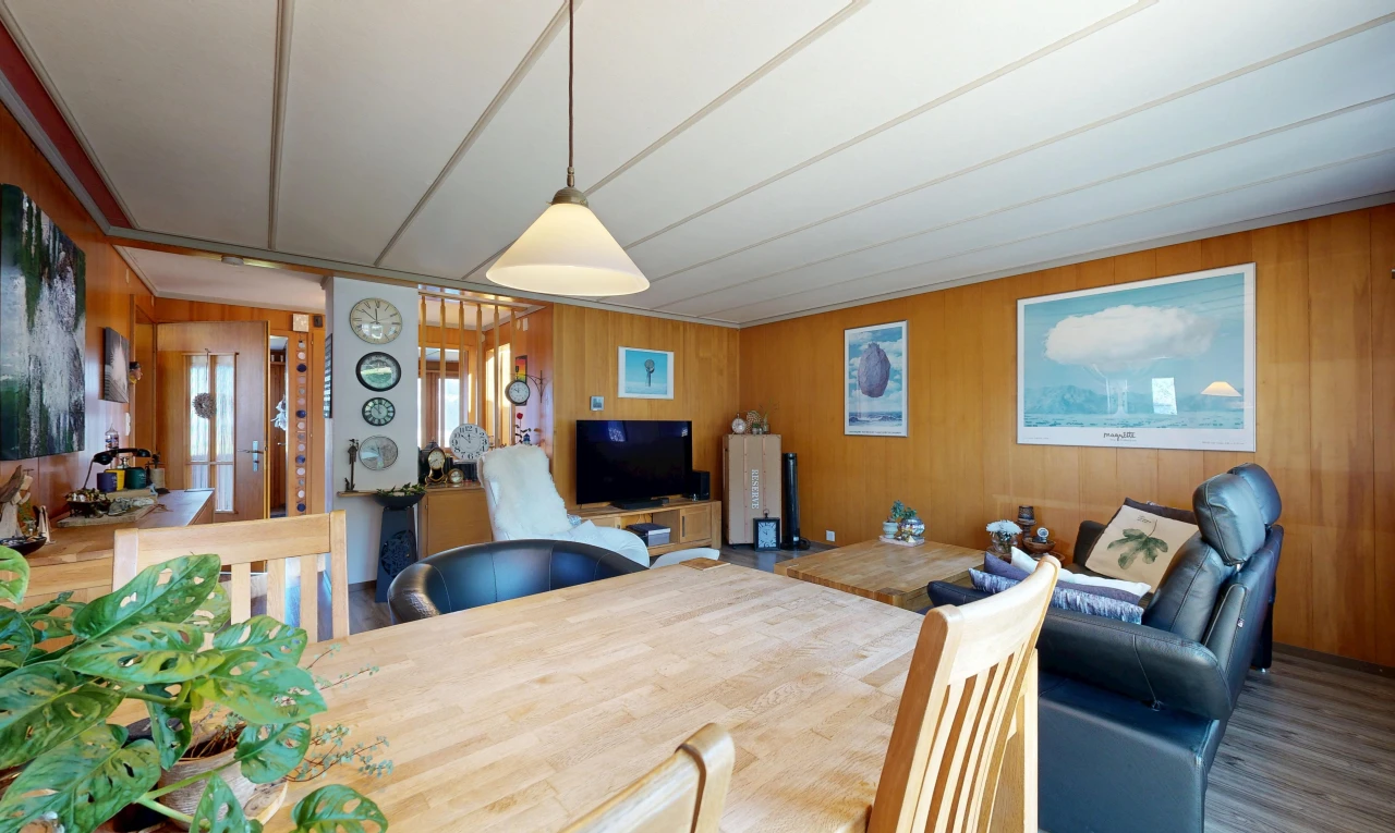 living / dining room with wood walls, decorative light fixtures, and wood finished floors