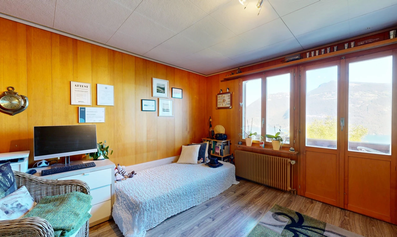 room featuring radiator, access to outside, wood finished floors, wood walls, and a mountain view