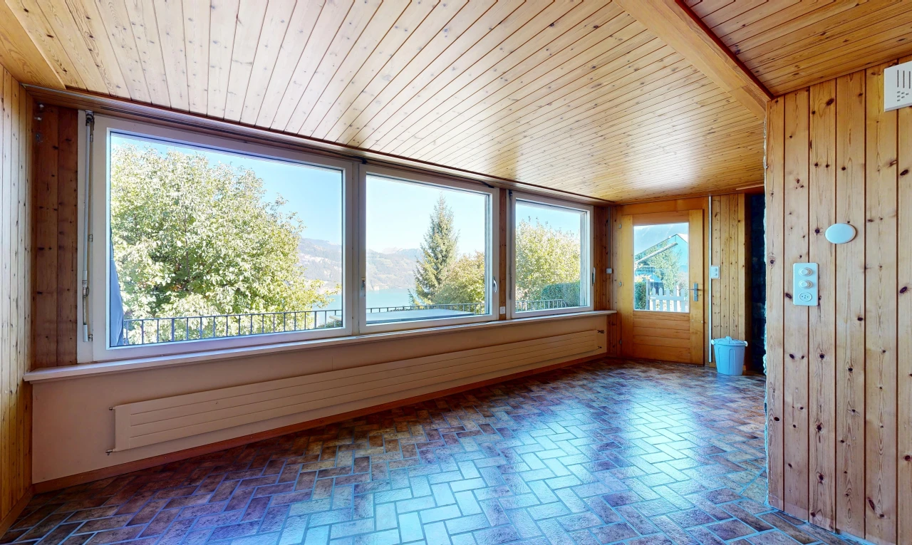 empty room with wooden walls, wood ceiling, access to outside, and brick patterned flooring