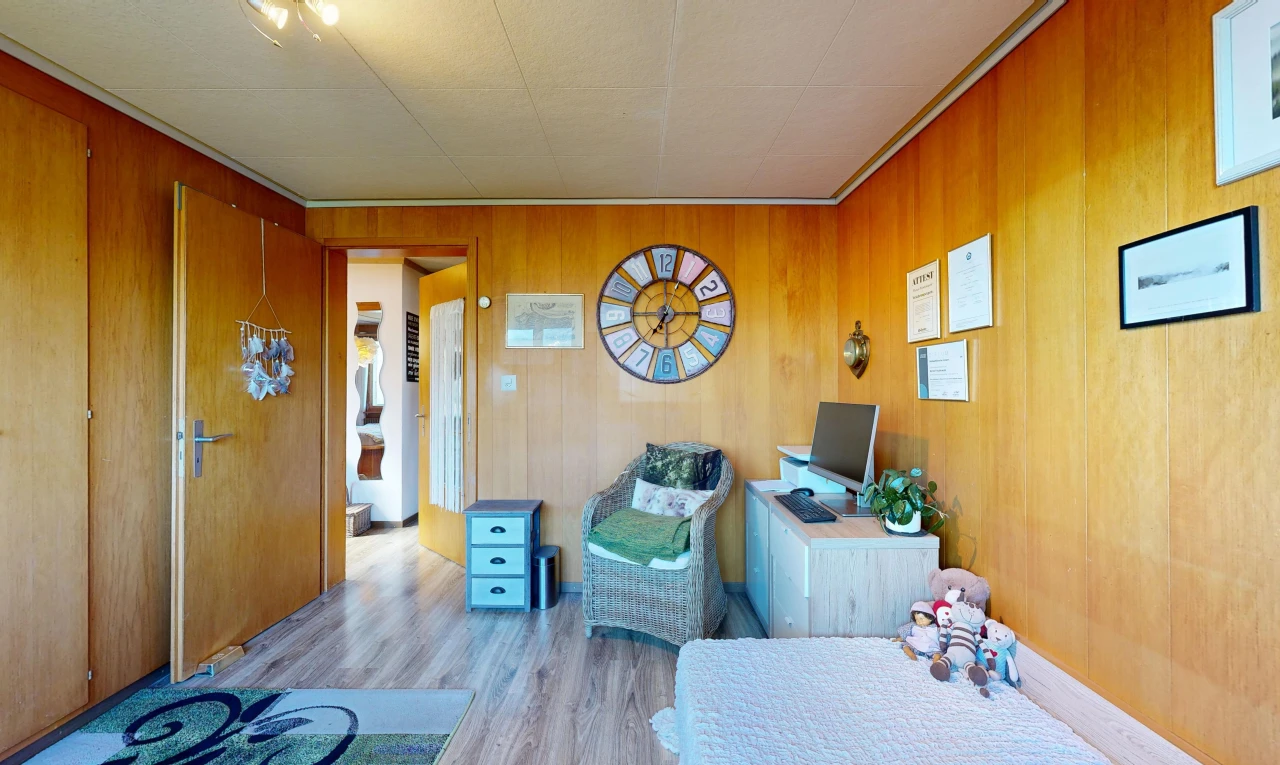room with light wood-style flooring and wooden walls