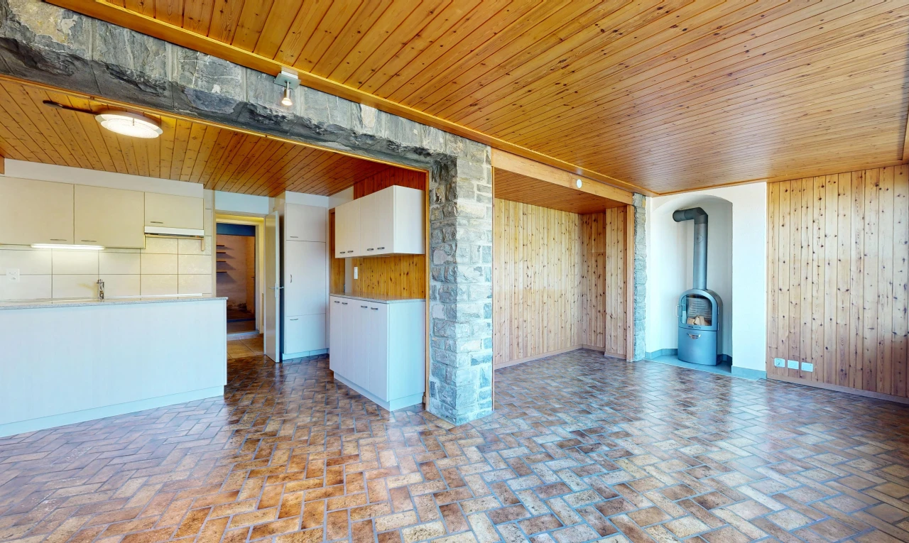 empty room with a wood stove, brick flooring, wooden walls, and wooden ceiling
