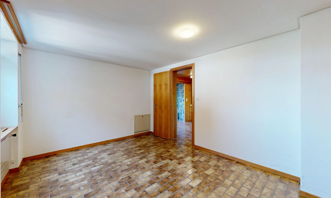 unfurnished room with baseboards and brick patterned flooring
