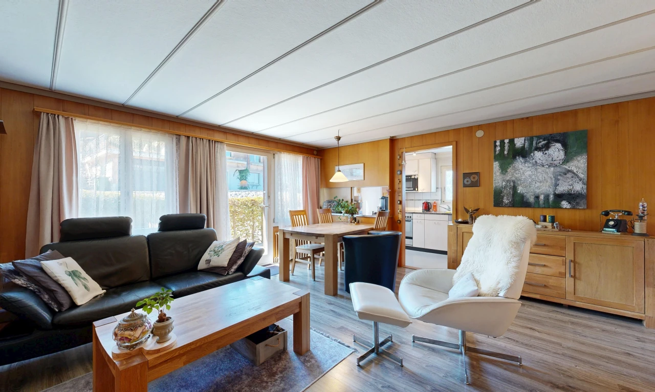 living / dining room with wooden walls, access to exterior, wood finished floors, and hanging light fixtures