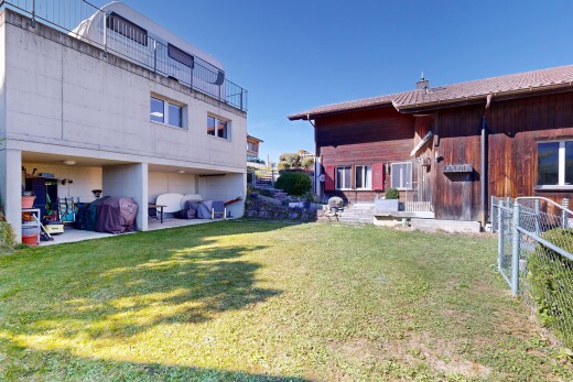 façade avec pelouse, clôture, bardage en bois, property visible, et day time