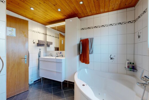 salle de bains avec plafond en bois, wood ceiling, miroir, mur en carrelage, et tile wall