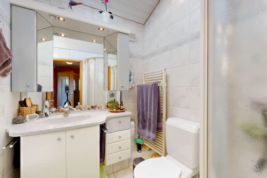 full bathroom with a towel warmer, radiator, tile walls, vanity, and a shower with shower door