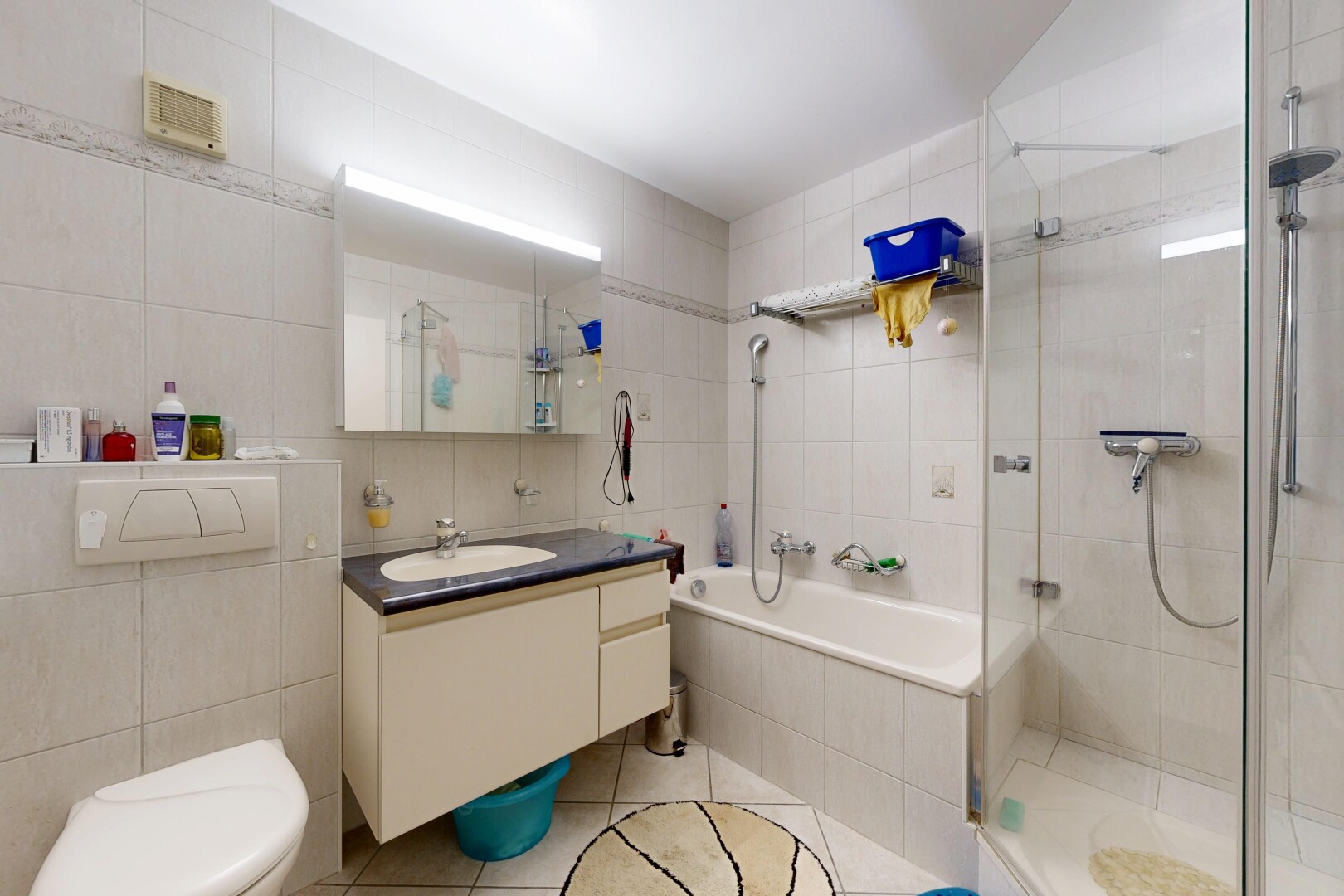 salle de bains avec tile wall, mur en carrelage, douche, light floor, et salle de bain complète