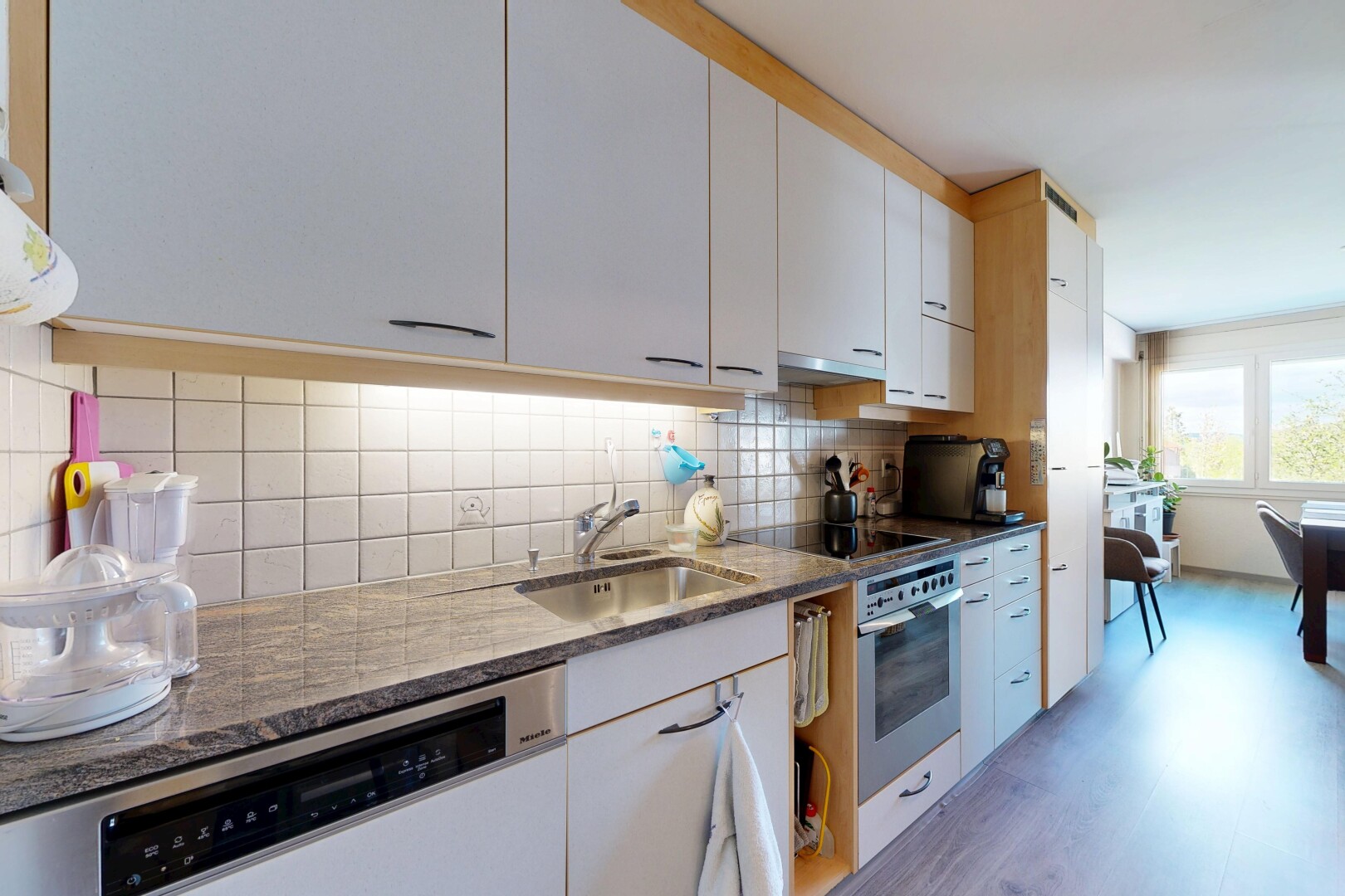 cuisine avec backsplash, dosseret, inside property, four, et stone countertops