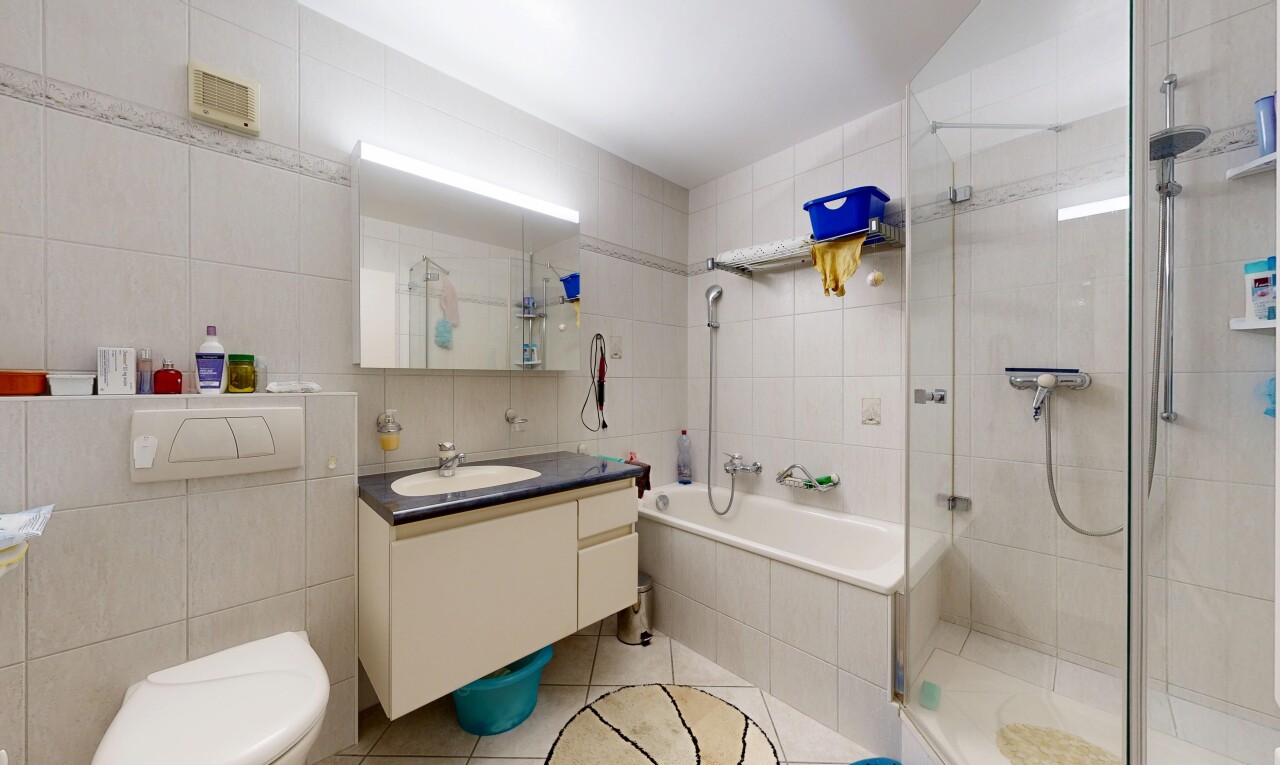 salle de bains avec tile wall, mur en carrelage, douche, light floor, et salle de bain complète