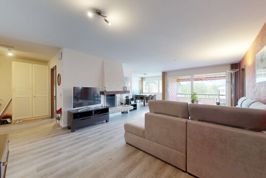 wohnzimmer mit wood finish floor, holzfußboden, inside property, fernseher, und natural light