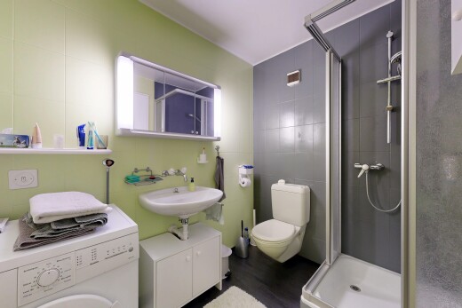 salle de bains avec lave-linge et sèche-linge, miroir, salle de bain complète, douche, et mur en carrelage