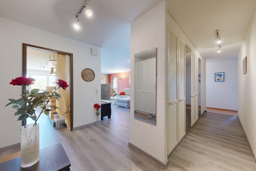 couloir avec inside property, sol en finition bois, wood finish floor, éclairage sur rail, et track lighting