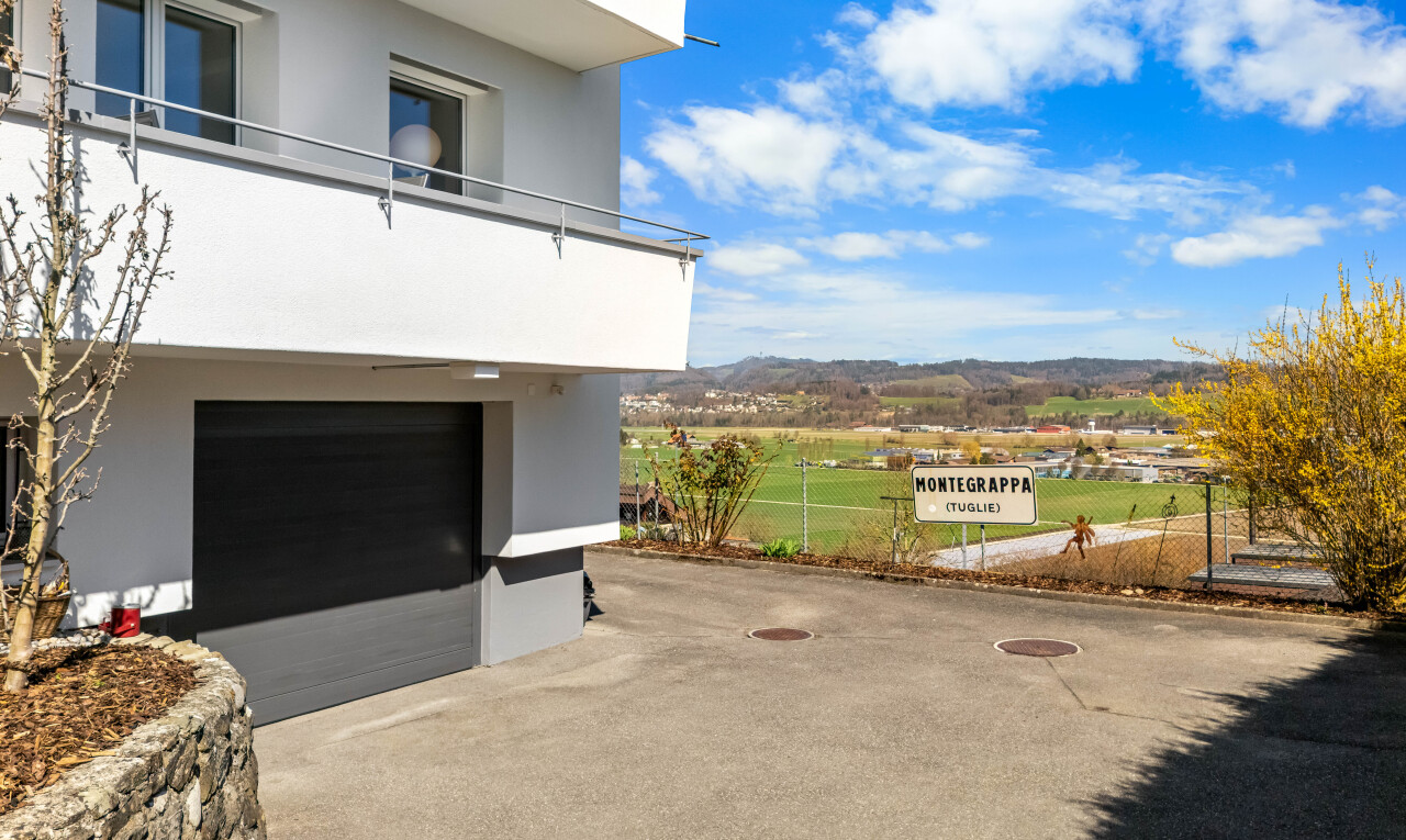 außenansicht mit balkon, eingebaute garage, stuckverkleidung, und zaun