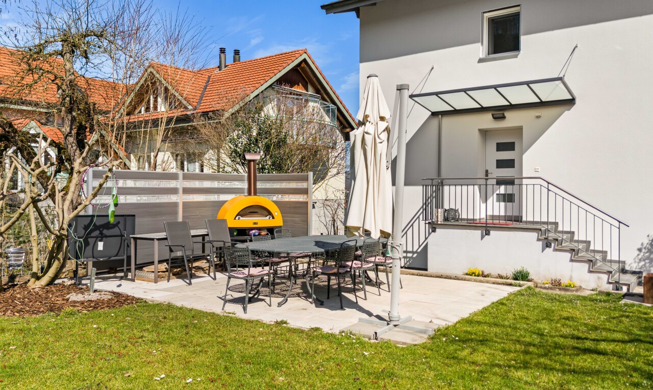 außenansicht mit rasen, terrasse, zaun, und stuckverkleidung