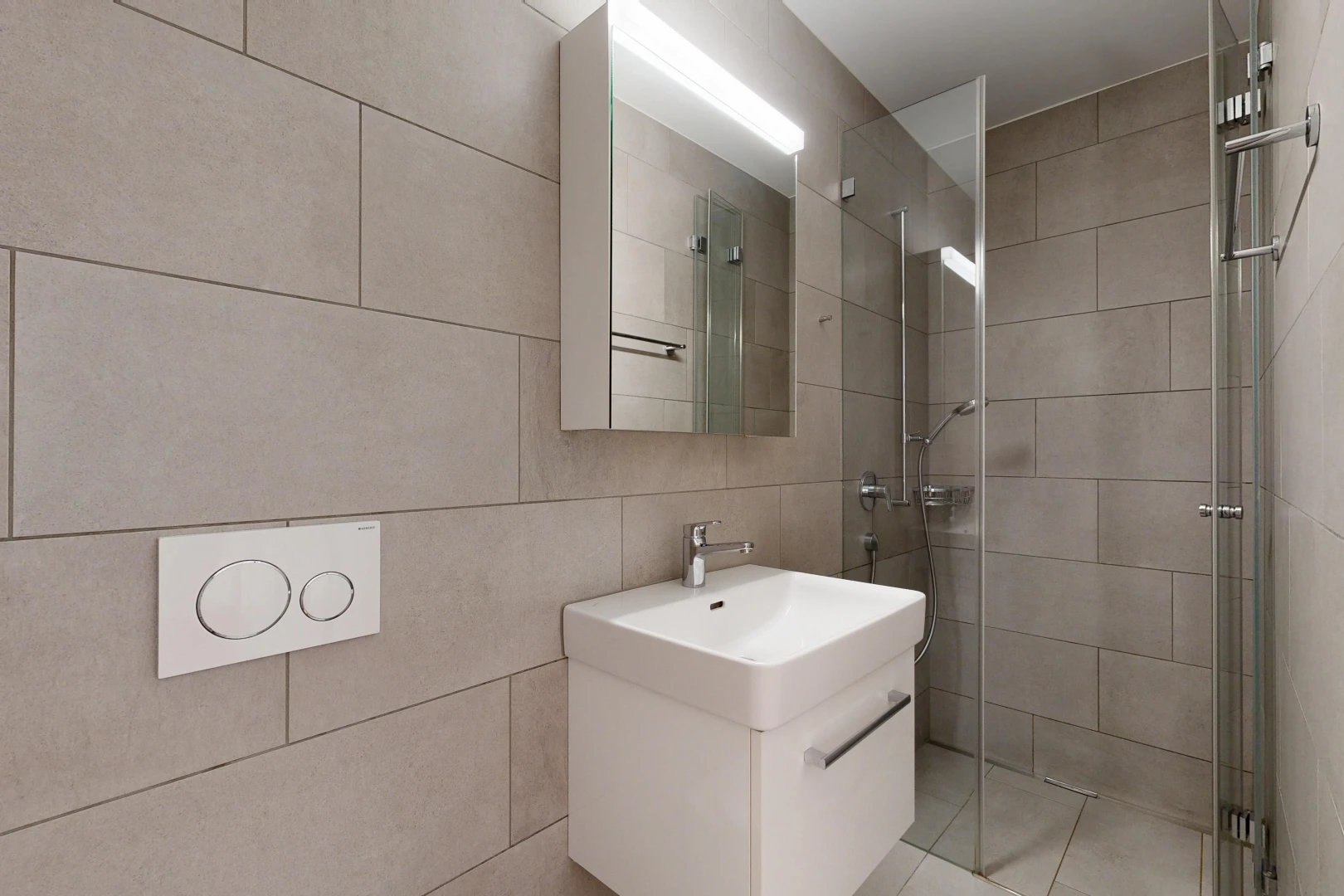 salle de bains avec douche, lavabo (ou coiffeuse selon le contexte), salle de bain complète, miroir, et light floor