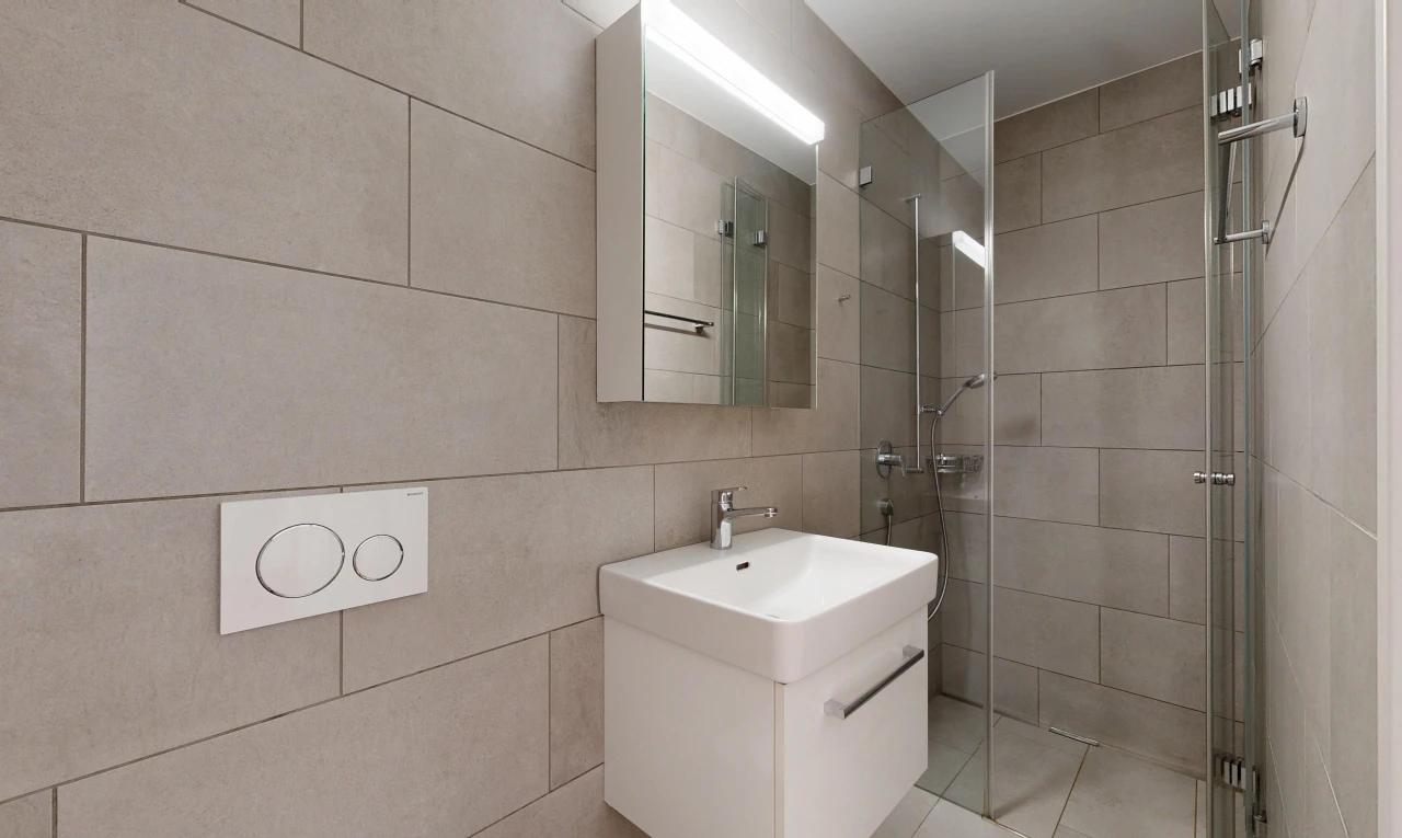 salle de bains avec douche, lavabo (ou coiffeuse selon le contexte), salle de bain complète, miroir, et light floor