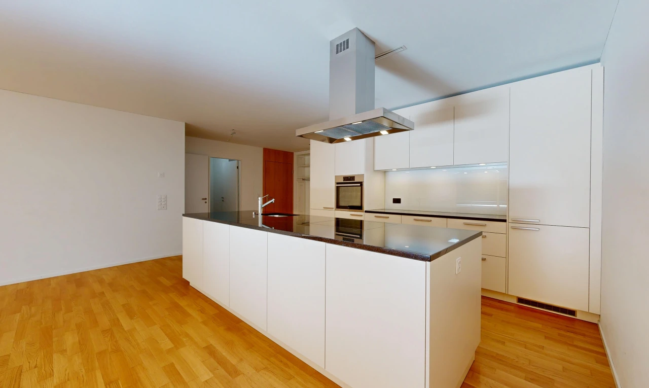 cuisine avec hotte, dark countertops, plans de travail, light floor, et flat panel cabinets