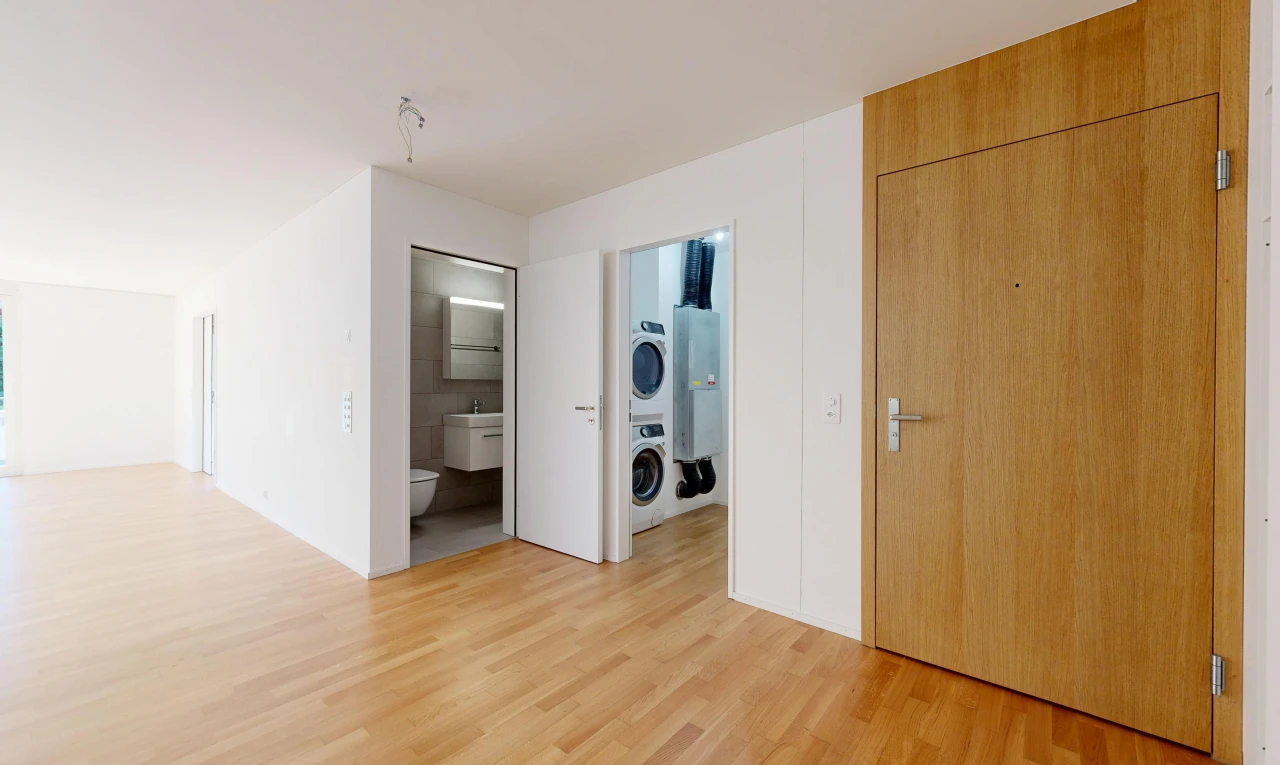 pièce vide avec lave-linge et sèche-linge superposés, light floor, wood finish floor, sol en finition bois, et inside property