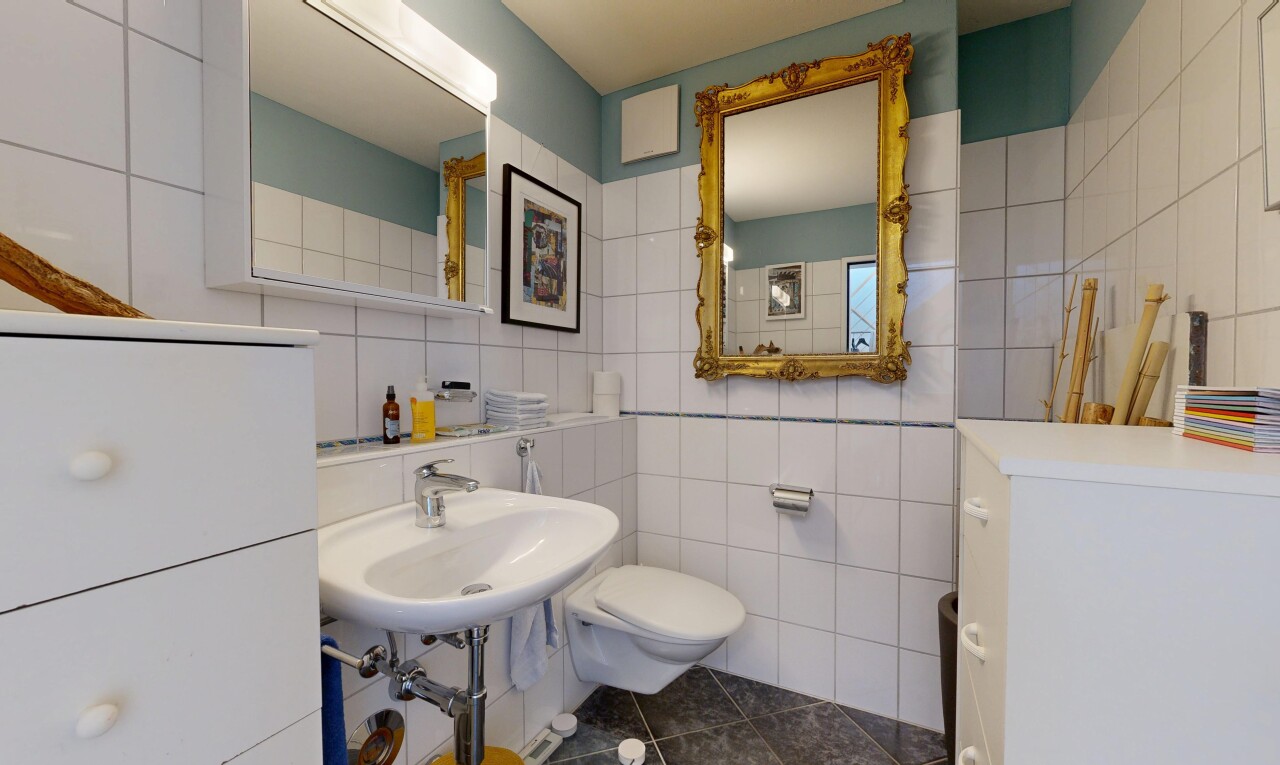 salle de bains avec tile wall, mur en carrelage, toilette, inside property, et dark floor