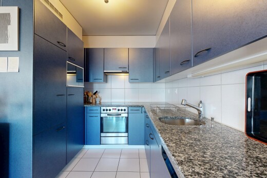 cuisine avec stone countertops, plans de travail en pierre, four, inside property, et light floor