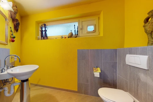 badezimmer mit waschbecken, fliesenwänden, fliesenböden und toilette