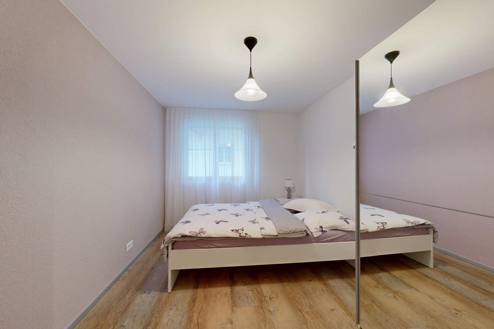 zimmer / schlafzimmer mit pendelleuchte, wood finish floor, holzfußboden, natürliches licht, und inside property