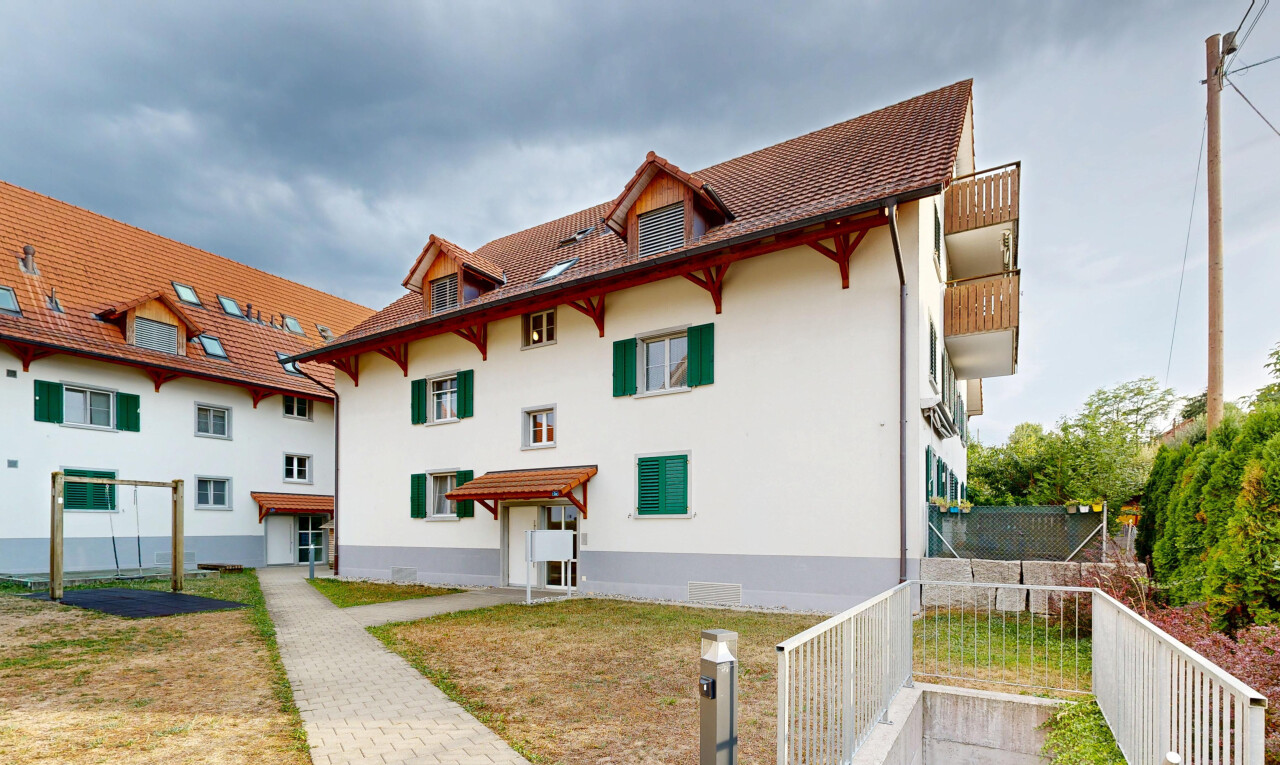 außenansicht mit dachgaube, zaun, stuckverkleidung, ziegeldach, und markise