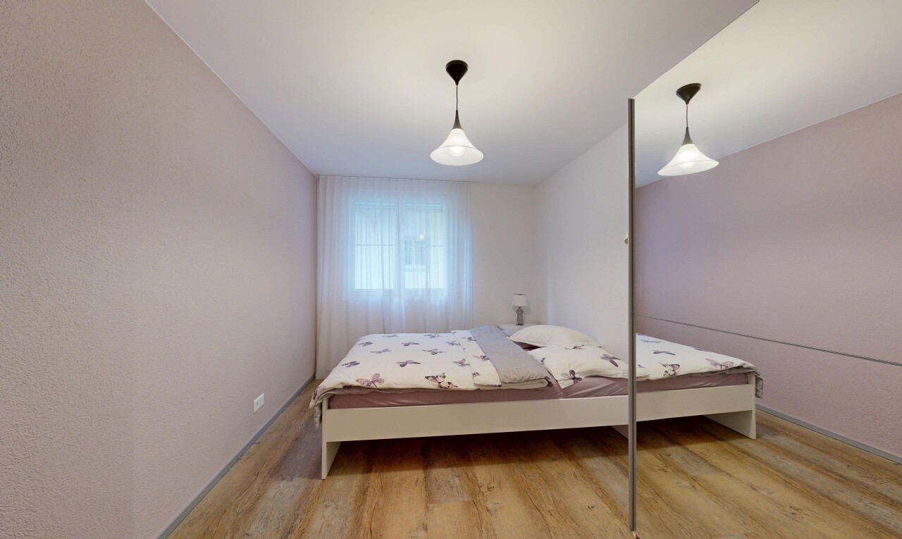 zimmer / schlafzimmer mit pendelleuchte, wood finish floor, holzfußboden, natürliches licht, und inside property