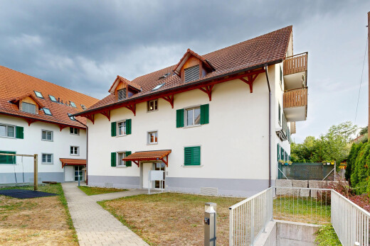 view of property with stucco siding and a tiled roof
