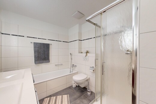 full bath with a stall shower, tile walls, vanity, dark tile patterned floors, and a garden tub
