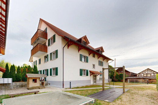 view of property featuring stucco siding, a yard, and a balcony