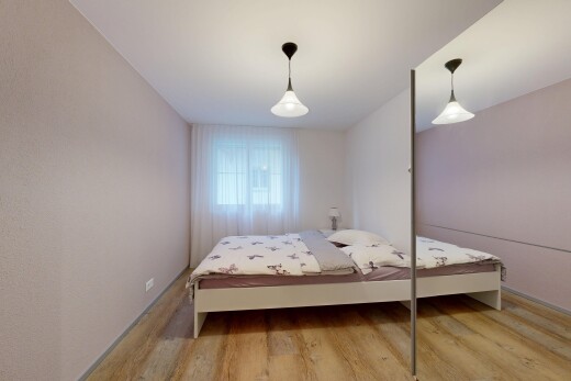 zimmer / schlafzimmer mit pendelleuchte, wood finish floor, holzfußboden, natürliches licht, und inside property