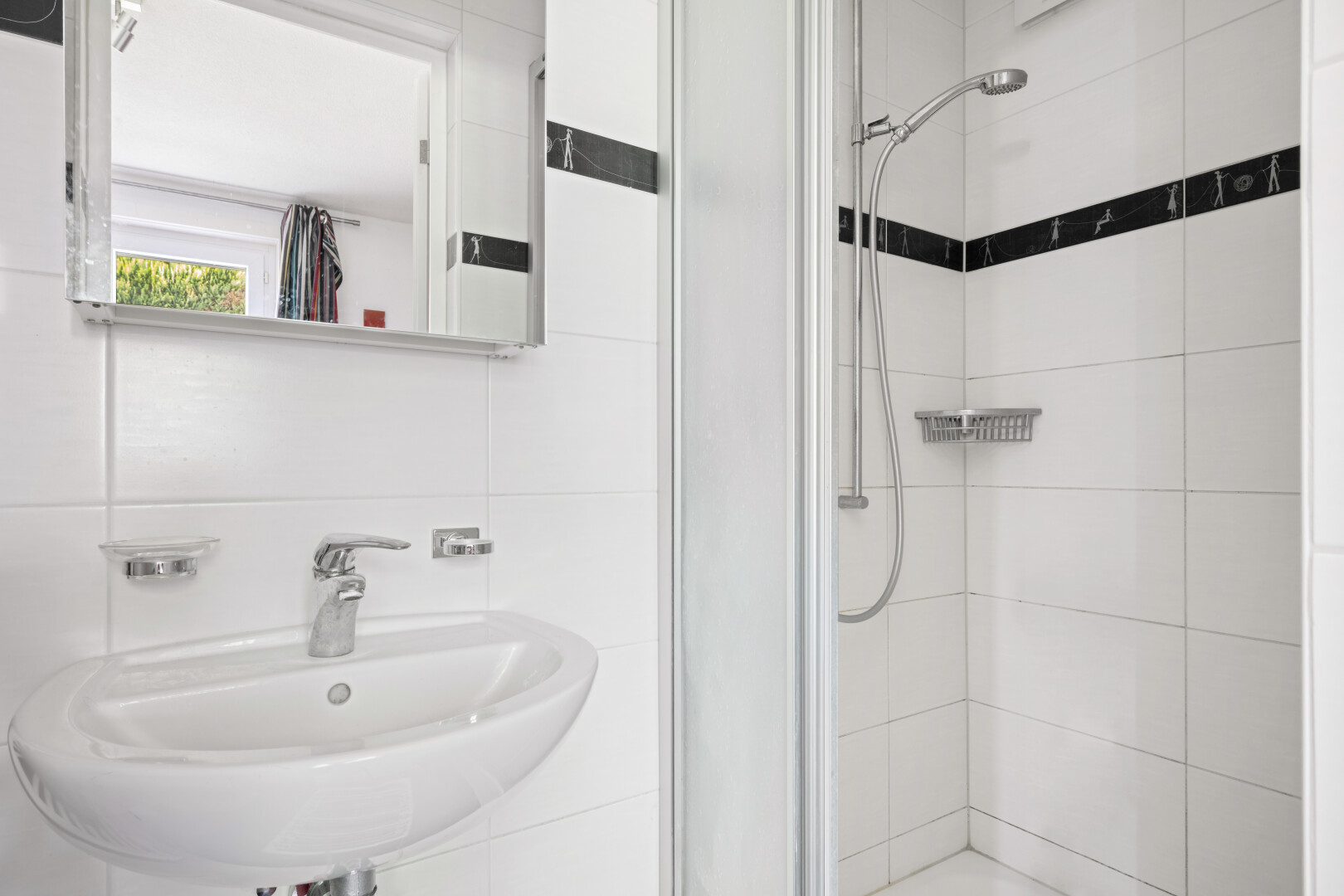 bathroom with a stall shower and tile walls