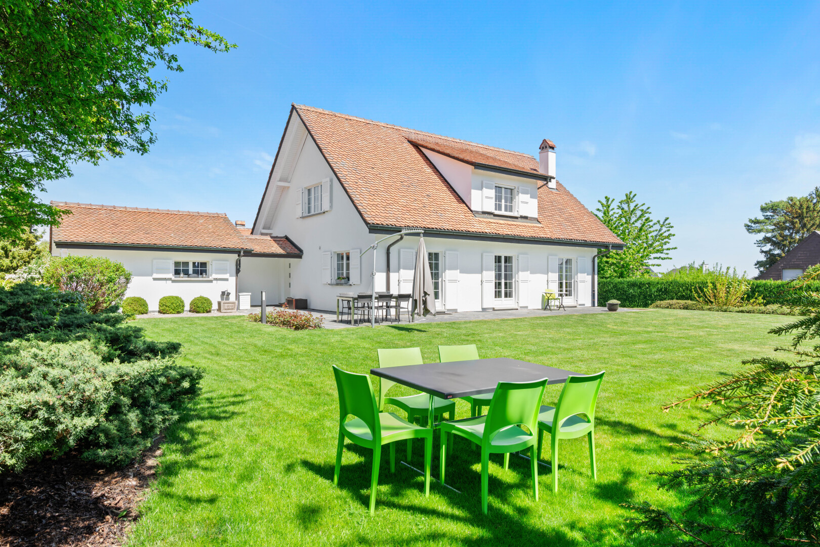 view of property with a chimney, a lawn, and a patio