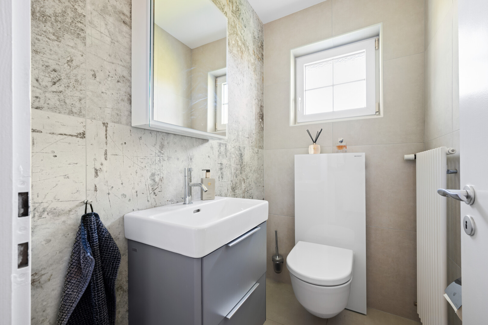 half bathroom with vanity, tile walls, and radiator heating unit