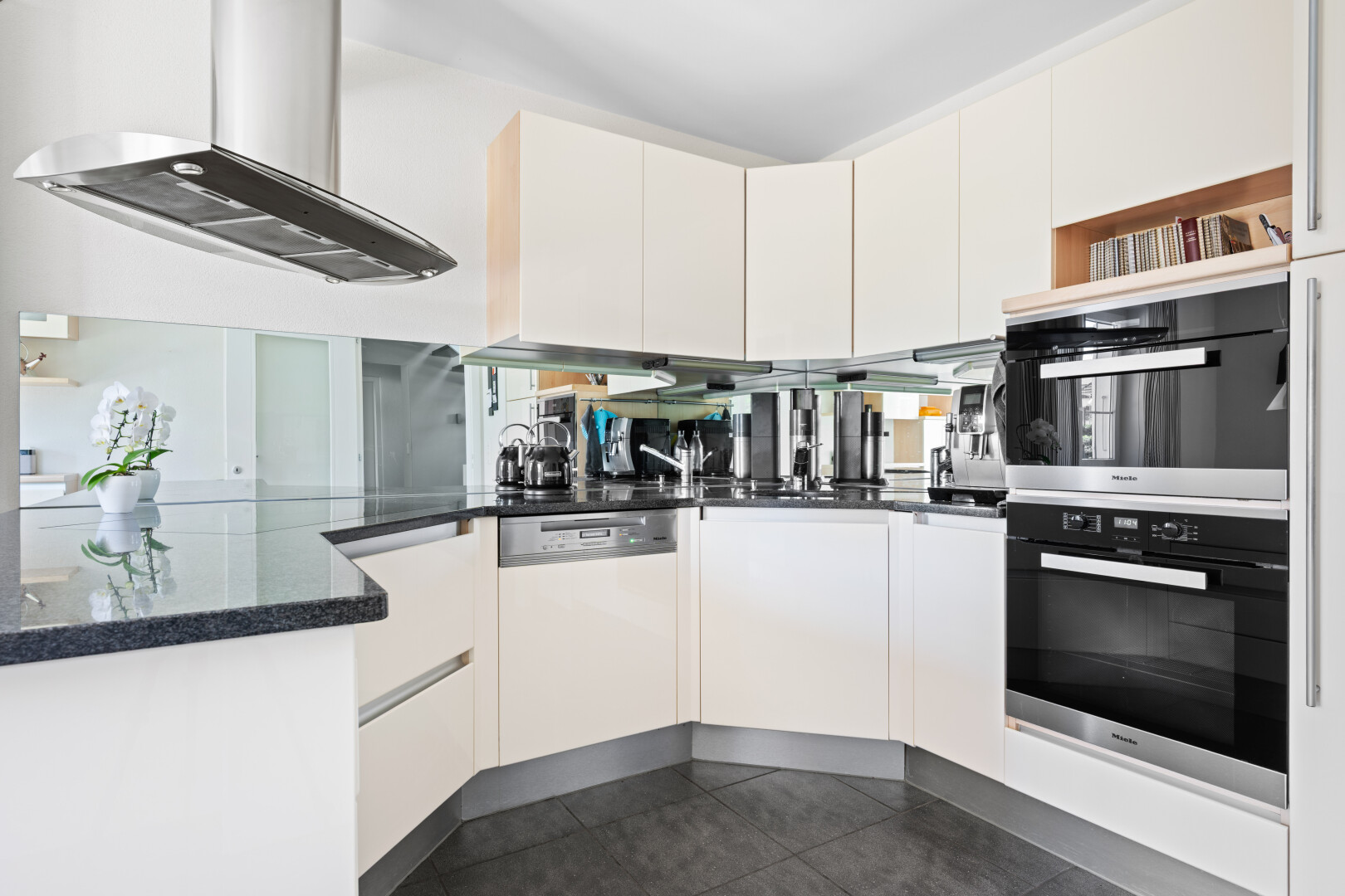 kitchen featuring ventilation hood, dark stone countertops, stainless steel double oven, dark tile patterned flooring, and white cabinetry