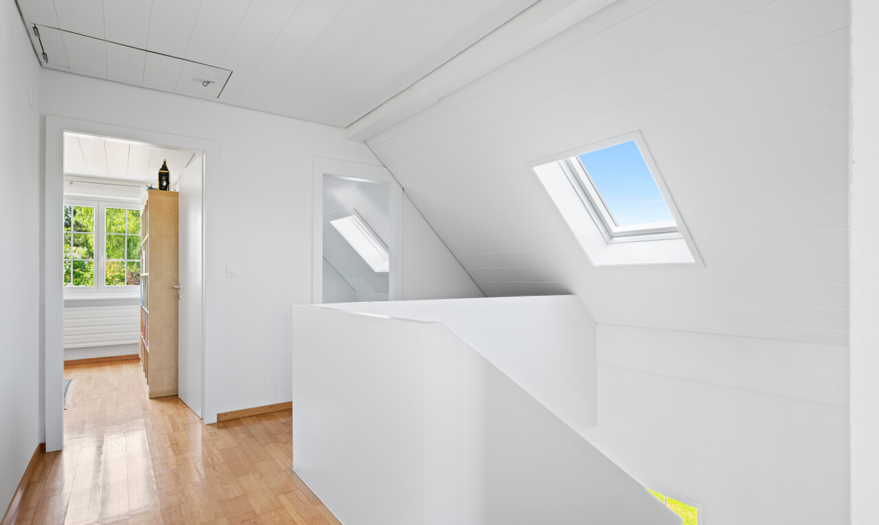 spare room with light wood-style floors, vaulted ceiling, and a skylight
