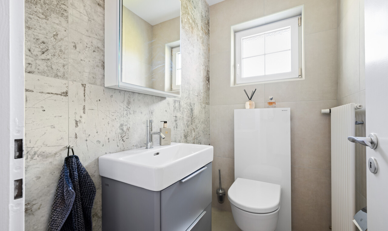 half bathroom with vanity, tile walls, and radiator heating unit