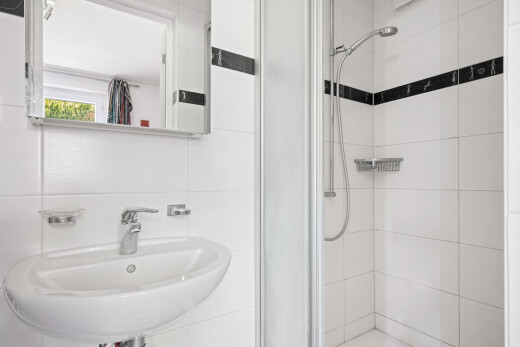 bathroom with a stall shower and tile walls