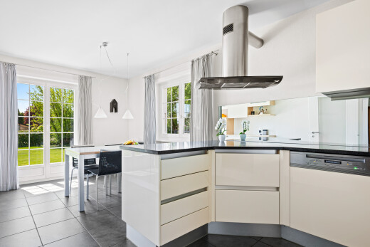 kitchen featuring island exhaust hood, dishwasher, dark countertops, and modern cabinets