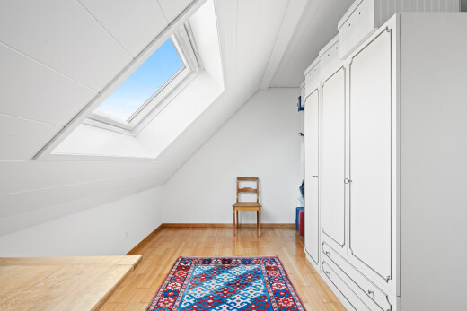 empty room featuring light wood-style flooring, vaulted ceiling, and a skylight