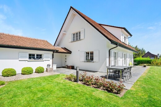 outdoor house featuring a lawn, a patio, and stucco siding