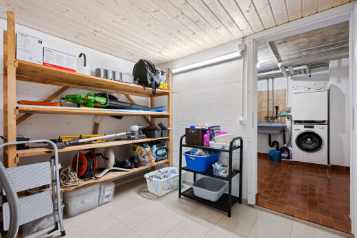 storage room with stacked washing machine and dryer and a sink
